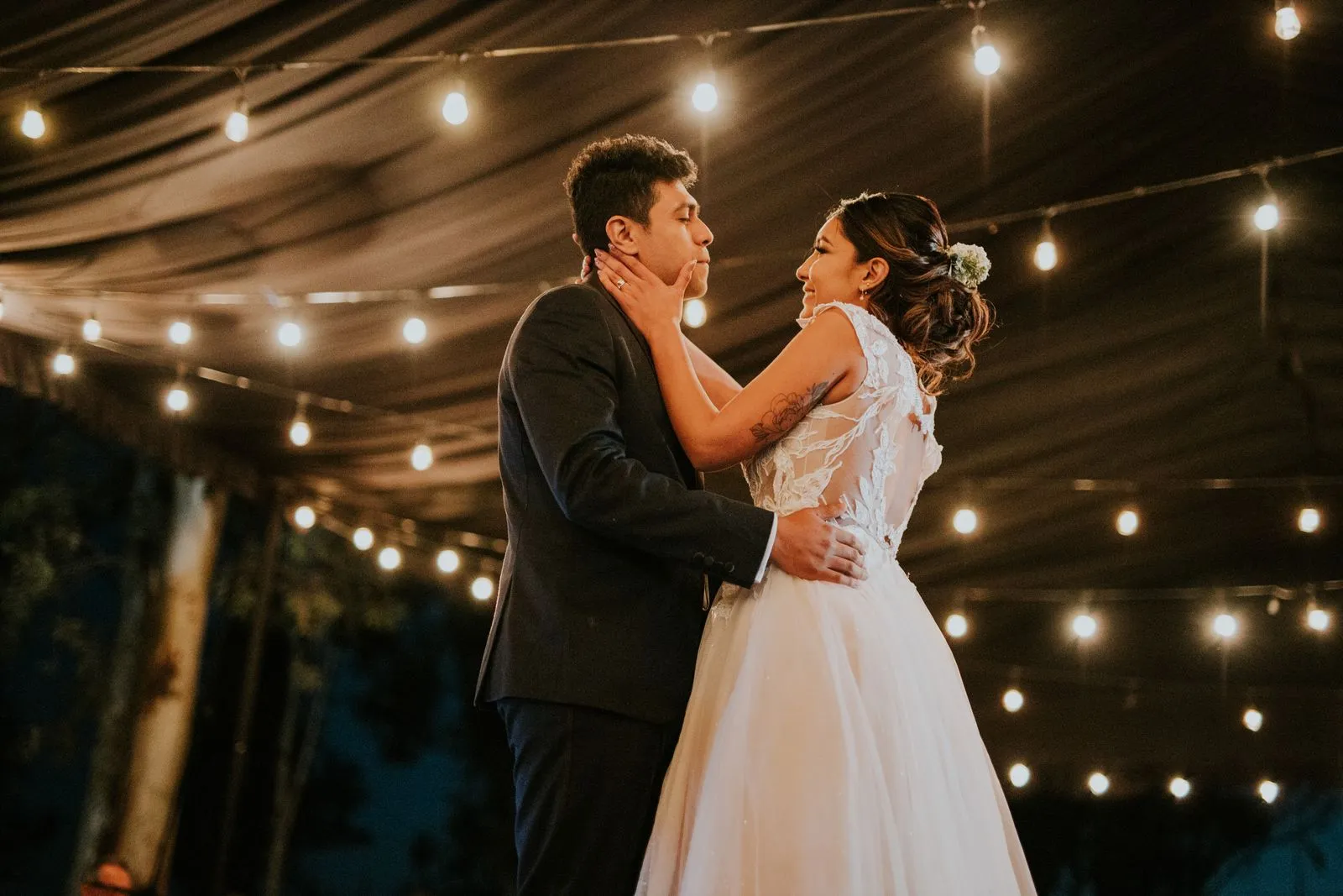 Bride and groom sharing a tender moment during their first dance with romantic lighting.