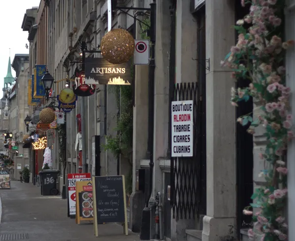 A picturesque street in Old Montreal showcasing 17th-century architecture and vibrant shop signs.
