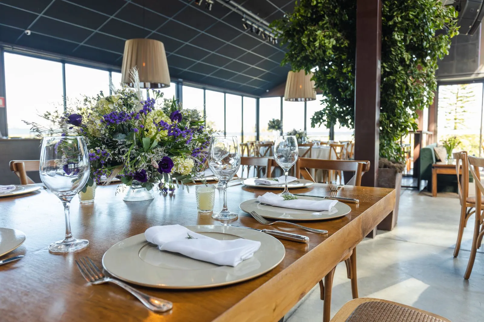 Art de la table, verrerie et compositions florales dans une salle lumineuse.