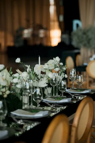 Elegant reception table with floral centerpiece and glassware, perfect for weddings.