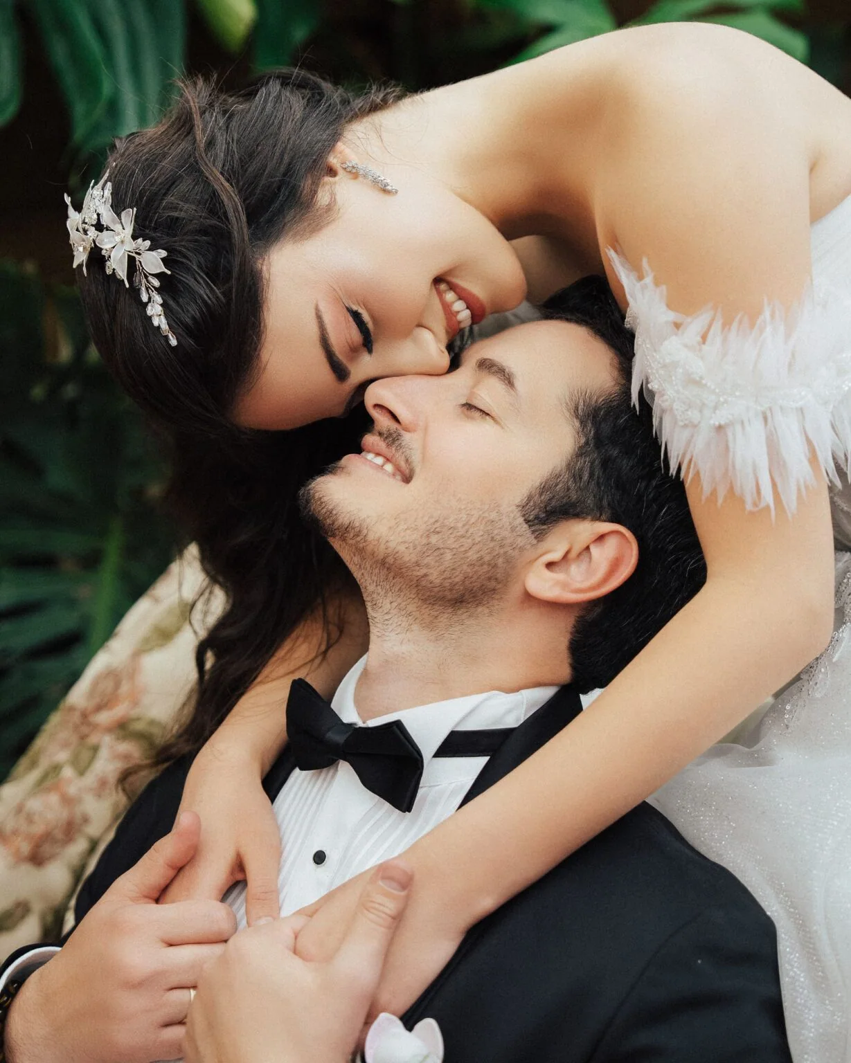 A couple lying in the grass shares a kiss.