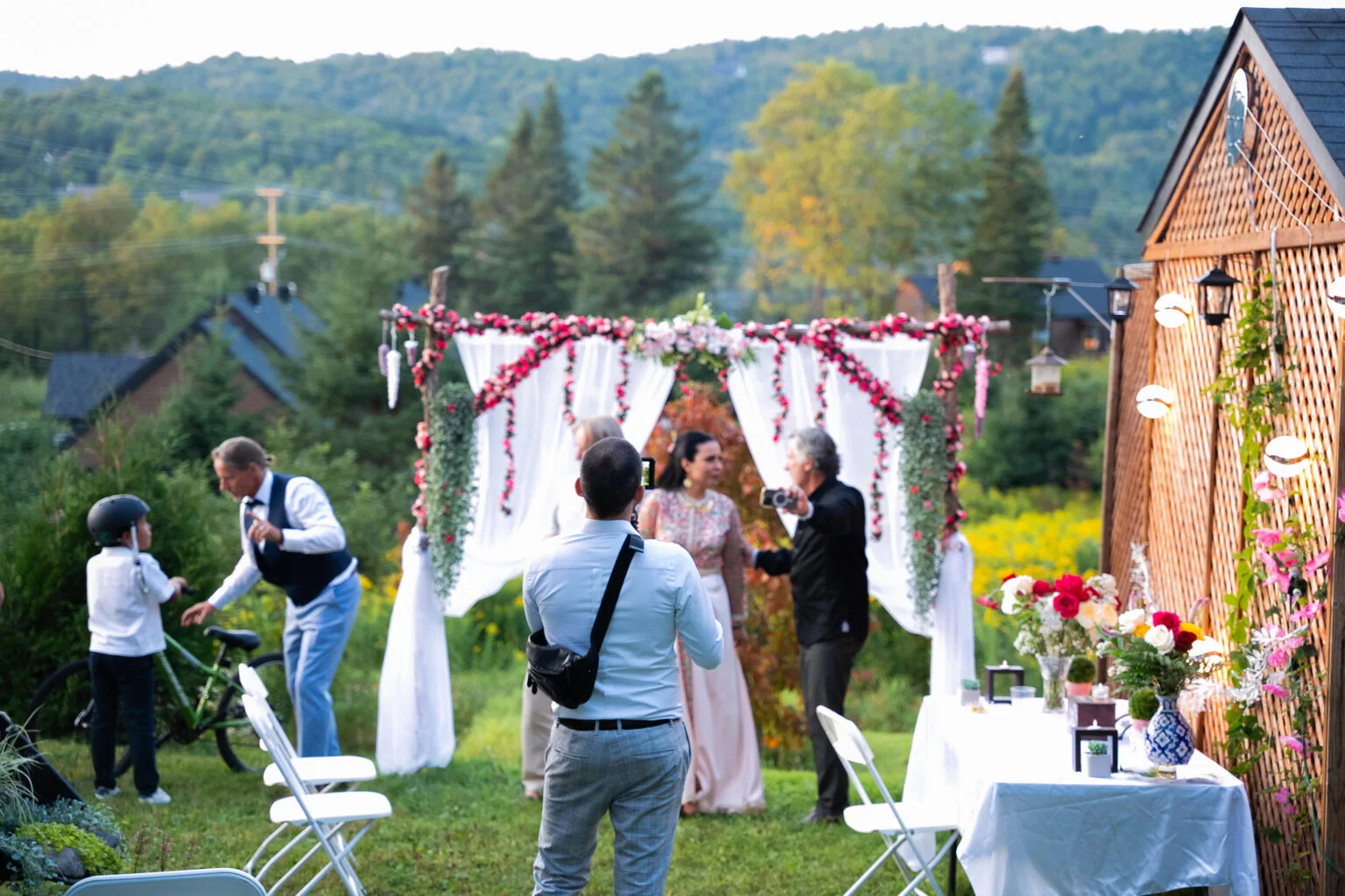 Guests gather around a wedding ceremony in a garden.